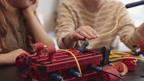 two people constructing robot