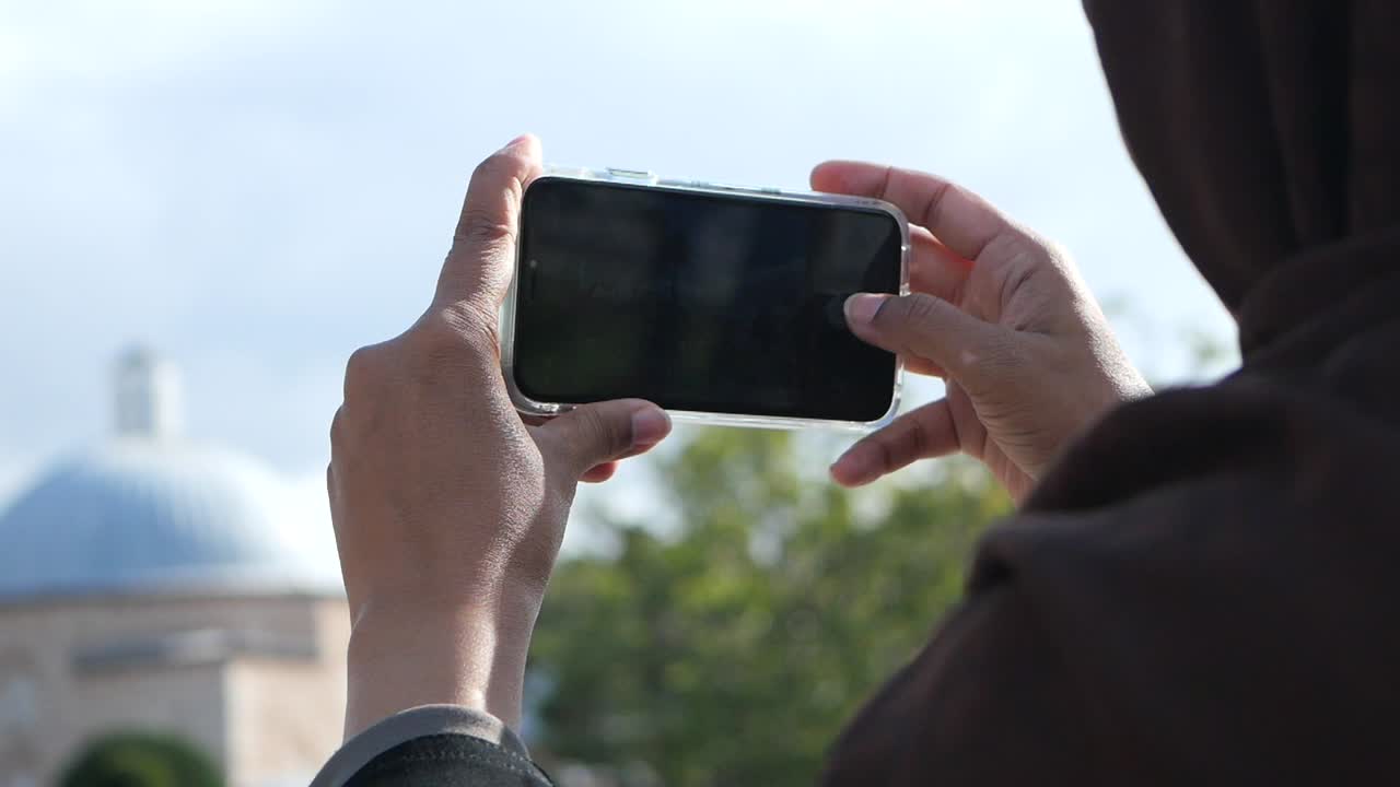 mujer tomando una foto de un edificio