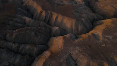 drone shot flying over the desert in the qobustan national park in azerbaijan at sunset while panning up