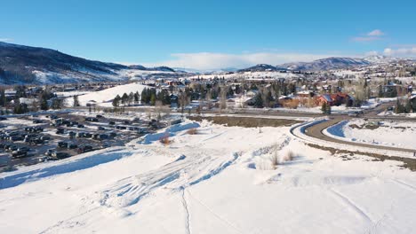 Vista-Del-Paisaje-Invernal-Con-Zona-De-Aparcamiento-Junto-A-La-Carretera-En-La-Estación-De-Esquí-Steamboat-Springs-En-Colorado-En-Un-Día-Soleado