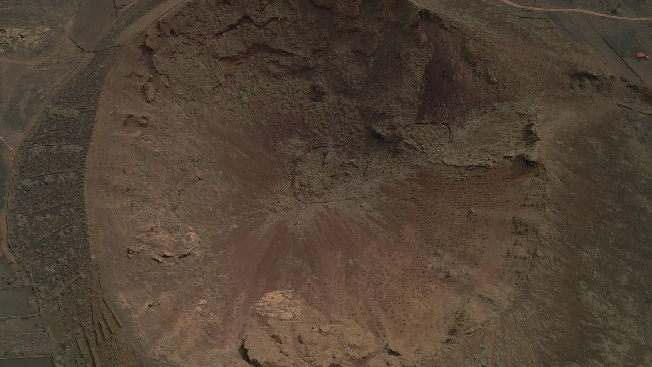 Volcanic eruption. Volcano crater. Aerial top view in orbit of volcano crater. Interior of a volcanic crater and lava outlet area. Canary Islands. Spain.