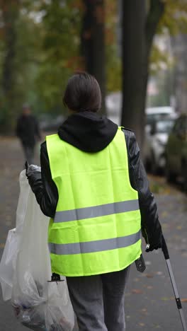 mujer limpiando la basura en la calle