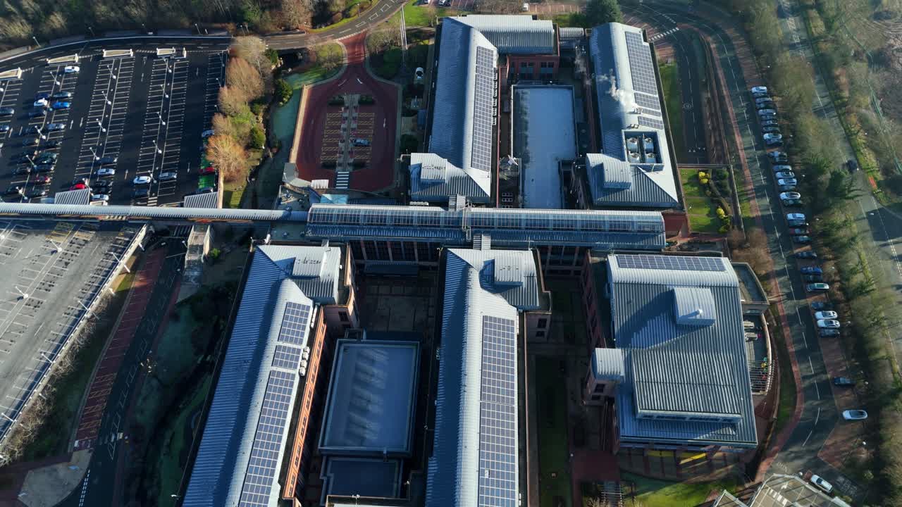 Droneoptagelse i høj højde af den indviklede glas- og stålarkitektur i National Grid kontorbygningen i Warwickshire, Storbritannien.