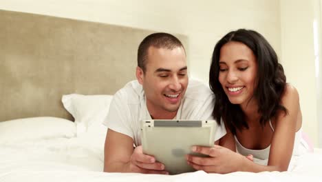 pareja usando el comprimido juntos en la cama