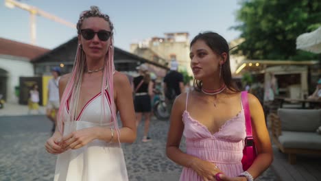 two young women in summer dresses on a city street