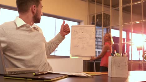 creative businessman giving coworker a thumbs up