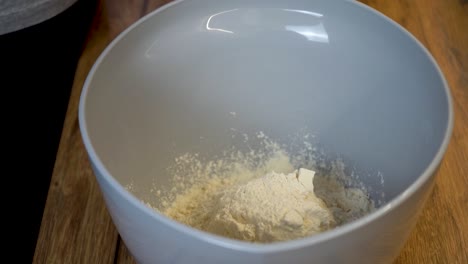 Woman-Adding-a-Spoon-of-Flour-to-a-Bowl