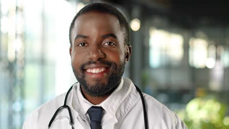 portrait of african american doctor with stethoscope looking at camera and smiling cheerfully