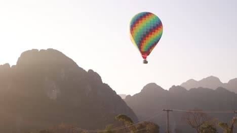 Colorido-Globo-Aerostático-Flotando-Entre-Los-Picos-De-Las-Montañas-En-Vang-Vieng,-La-Capital-De-Aventuras-De-Laos.