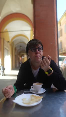 person enjoying coffee and bread in an outdoor cafe