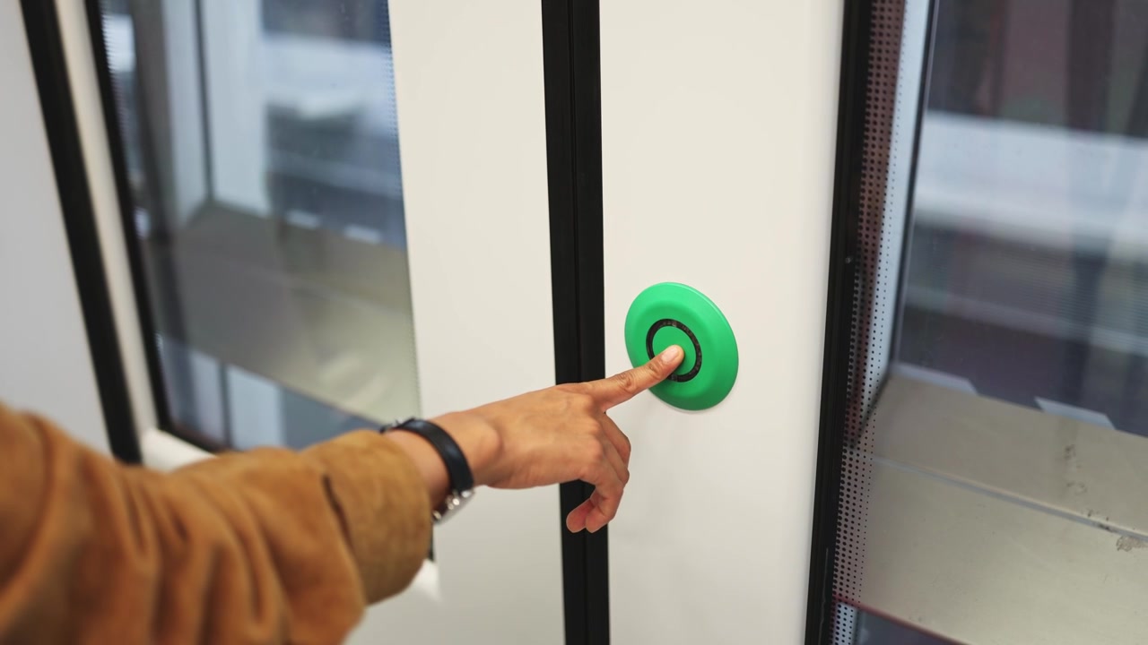 Persona pulsando botón verde para abrir las puertas del tren y salir