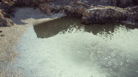 clear, calm water in a rocky tide pool on a beach