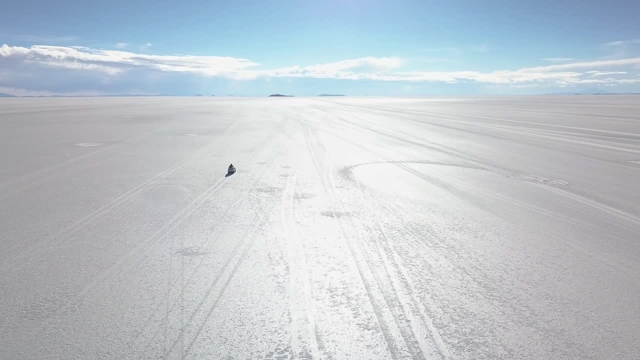 볼리비아의 소금 평야에서 4x4를 운전하는 공중 촬영