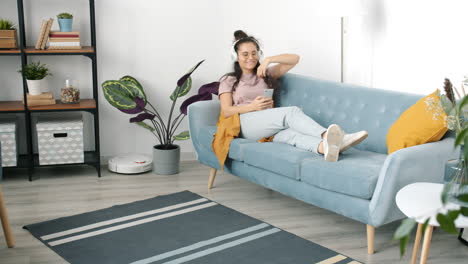 woman relaxing on a sofa using a phone
