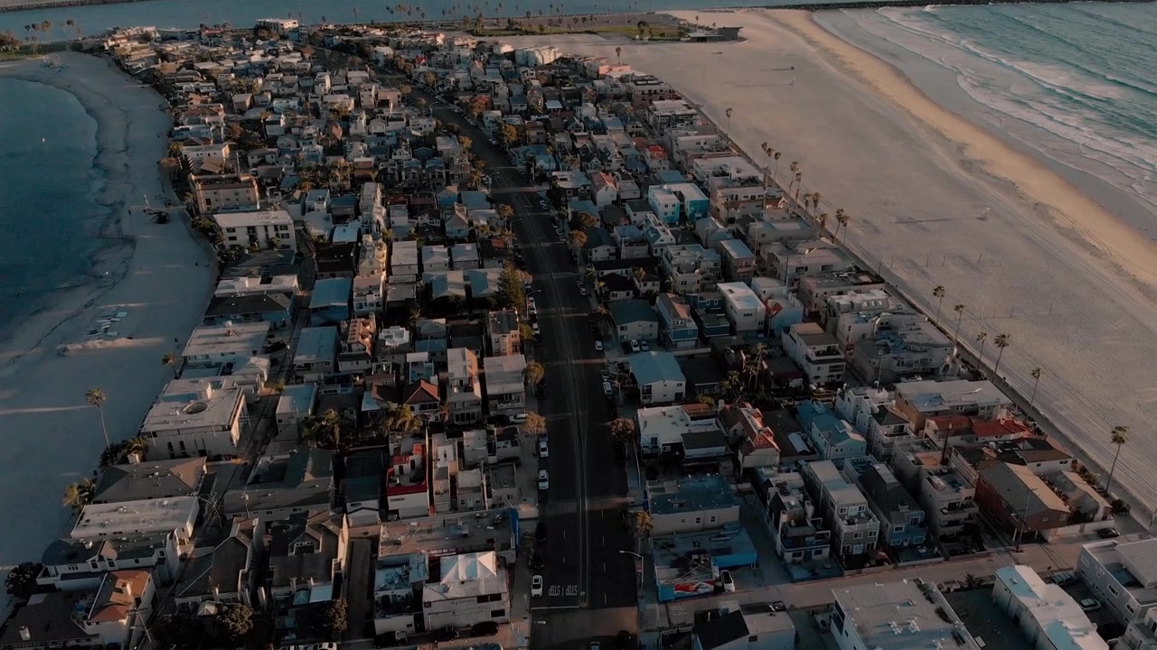 Elevando-se Acima das Praias de San Diego. Esta cidade costeira de San Diego, chamada Mission Beach, é cercada pelo oceano e pela baía. Esta imagem foi capturada ao pôr do sol em uma bela noite, por um drone.