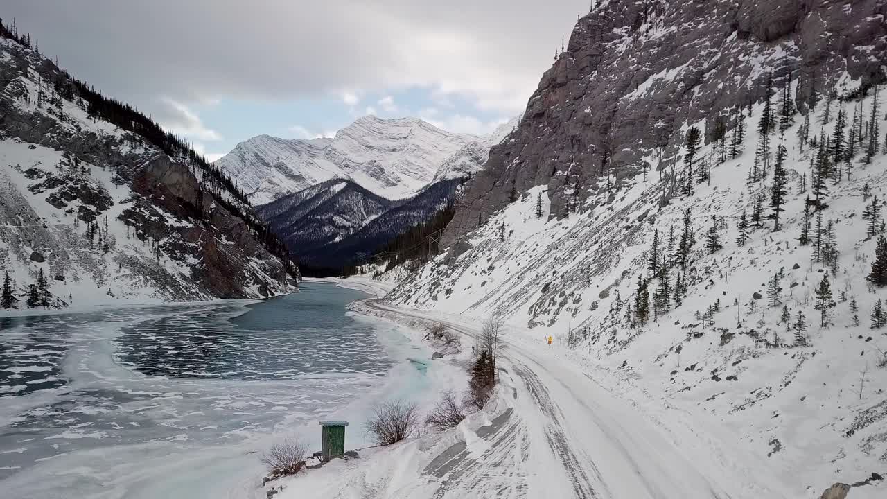 People driving through the beautiful Spray Lakes Reservoir in Canada - aerial