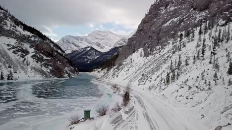 people driving through the beautiful spray lakes reservoir in canada - aerial