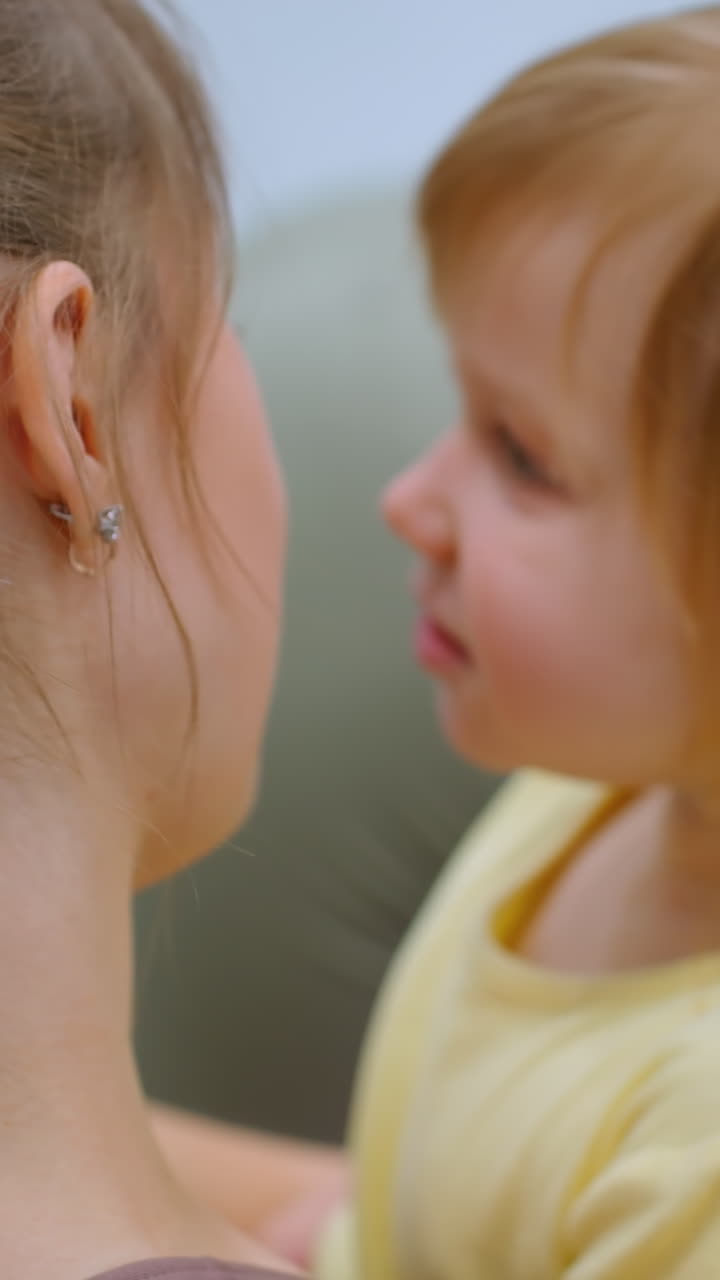 Momento intimo tra madre e figlia che si abbracciano calorosamente, con la sottile attività di sfondo di qualcuno che si allena in palestra.