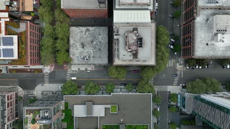 top down aerial view of cars a white car driving through seattle's downtown streets