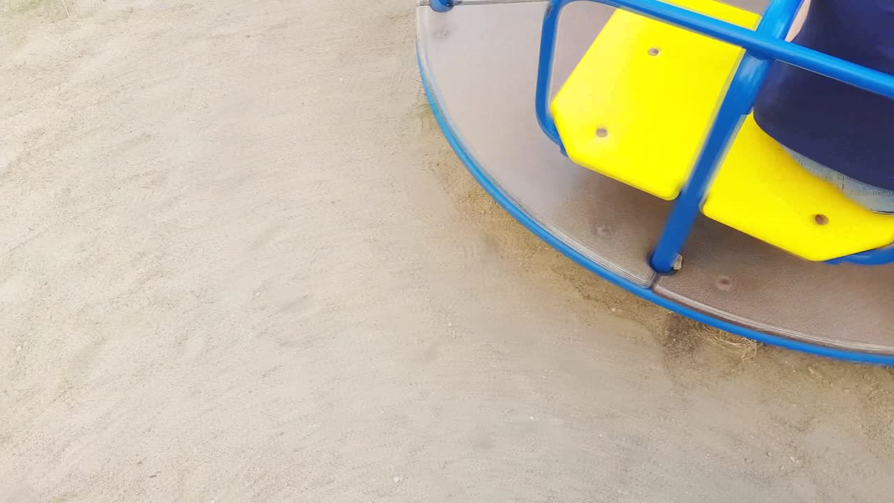carrusel infantil giratorio rápido en el patio de recreo vista superior, video 4k