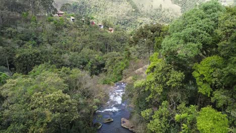 Uphill-movement-with-drone-amidst-many-trees-and-waterfall