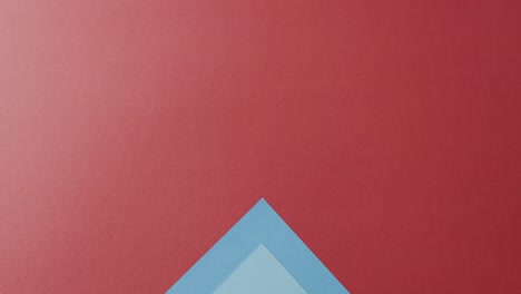 Close-up-of-blank-and-blue-cards-on-red-background-with-copy-space-in-slow-motion