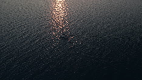 Sailboat-Sailing-On-The-Calm-Sea-With-Reflections-Of-Sky-Shining-On-The-Water-Surface-During-A-Sunrise-In-Quebec,-Canada