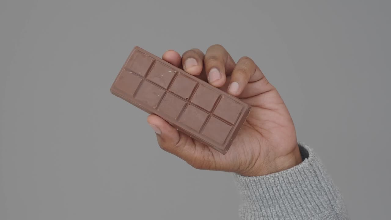 mano con una barra de chocolate