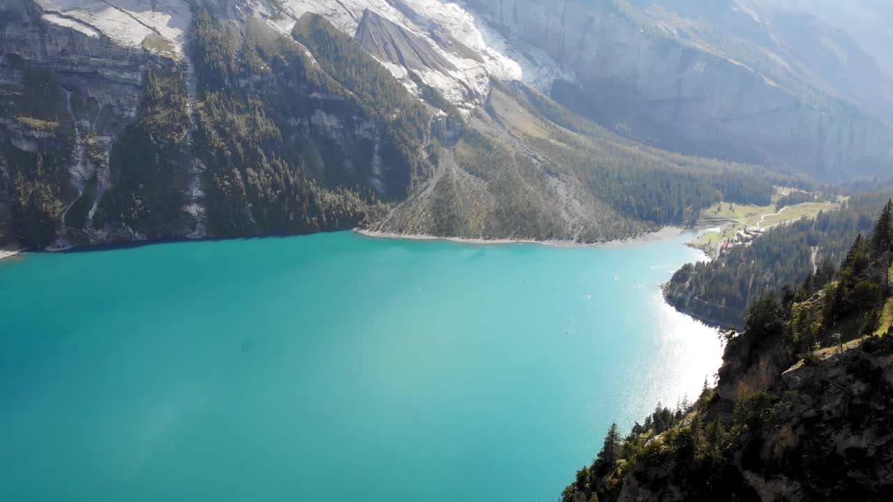 sobrevuelo aéreo junto a los acantilados que rodean el lago turquesa oeschinensee en kandersteg, suiza