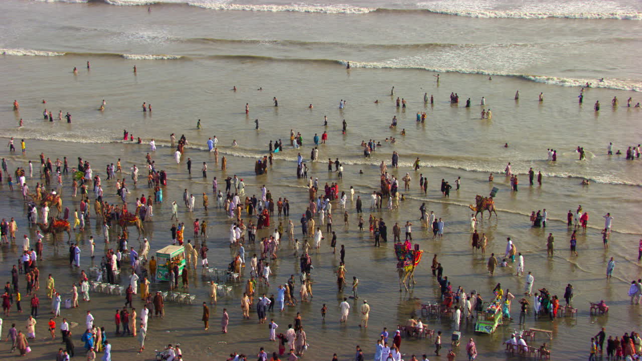 카라치 파키스탄의 바다 전망 해변의 공중 전망, 수백 명의 사람들이 바다의 파도에 아름다운 태양 광선을 즐기기 위해 함께 있습니다