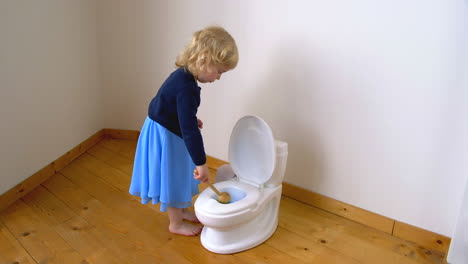 un niño limpiando un retrete con detergente y un cepillo