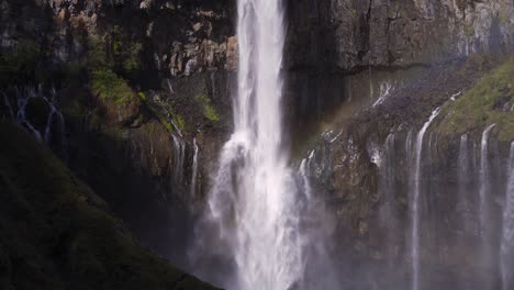 close up shot of waterfall falling down on cliffs with running water