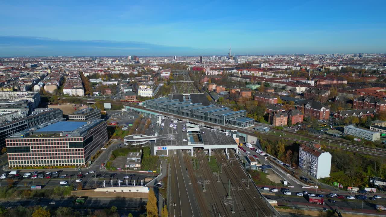 Berlin cityscape with a modern train station South Cross and extensive railway lines under a clear sky. Lovely aerial view flight static tripod hovering drone