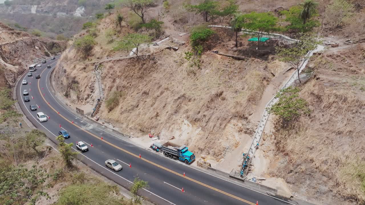 vista aérea de un avión no tripulado: carretera de montaña sinuosa con vehículos que atraviesan un terreno rocoso