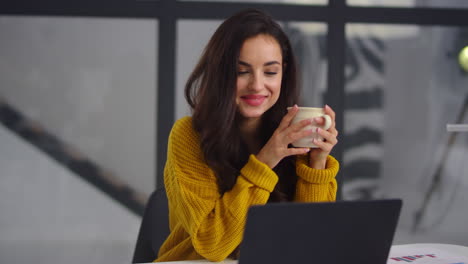 closeup business woman looking laptop. smiling girl drinking tea near notebook