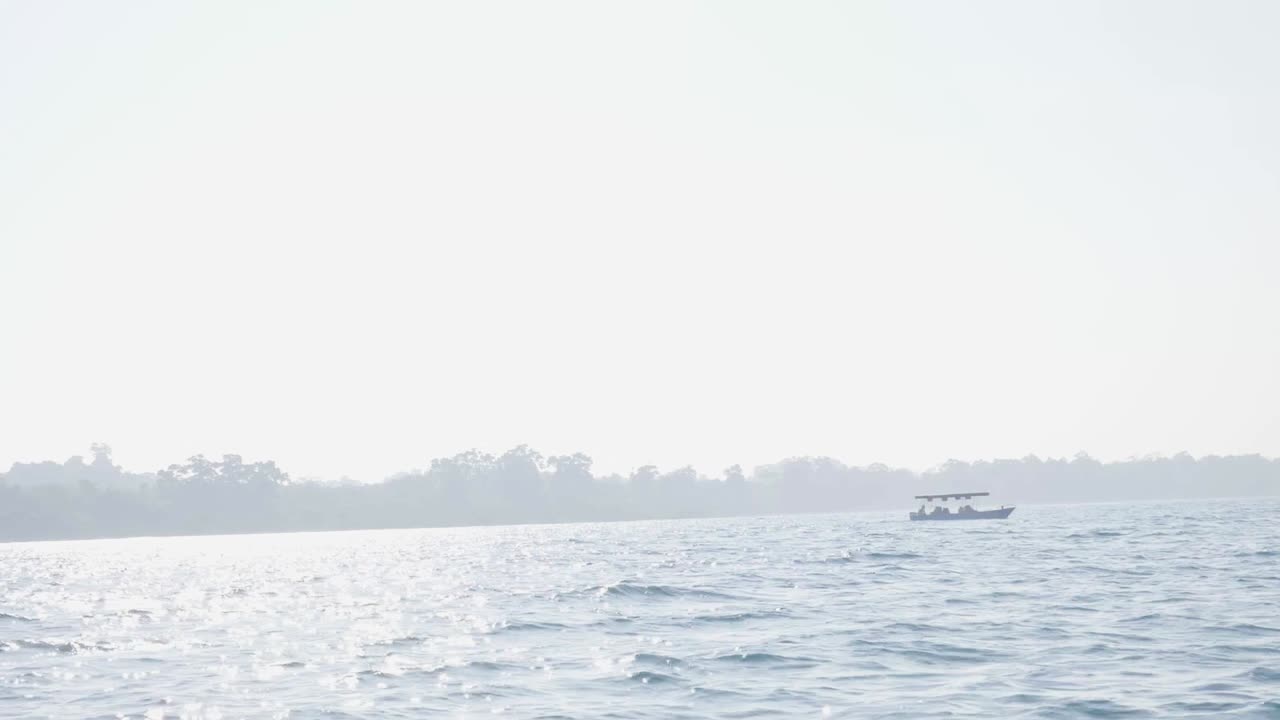 A lone boat on a calm sea under a bright sky