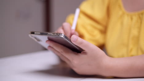 Detail-of-female-hands-writing-on-tablet-with-digital-pen