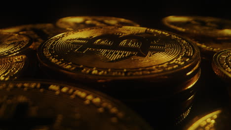 a gold bitcoin on a rotating platform against a dark background - close up