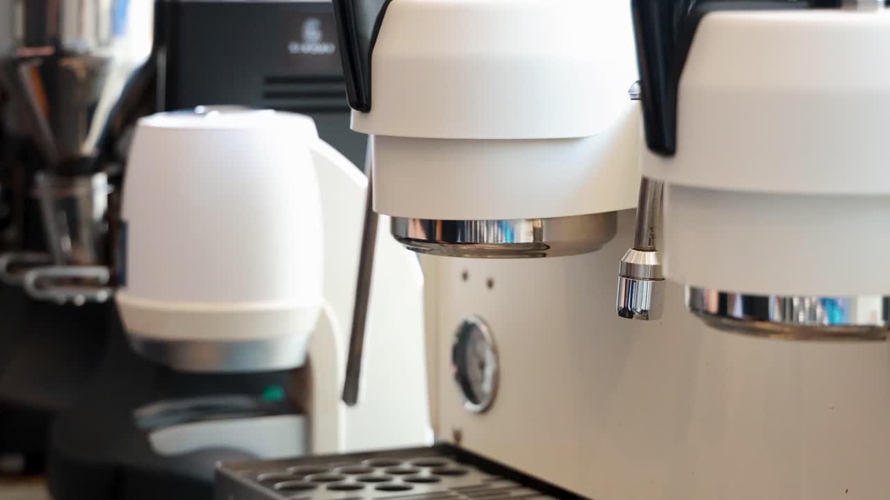 A close-up view of an espresso machine in a Phuket cafe, highlighting its sleek design and ambient lighting