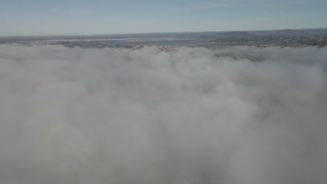 flying above a thick layer of clouds towards an open area in the clouds