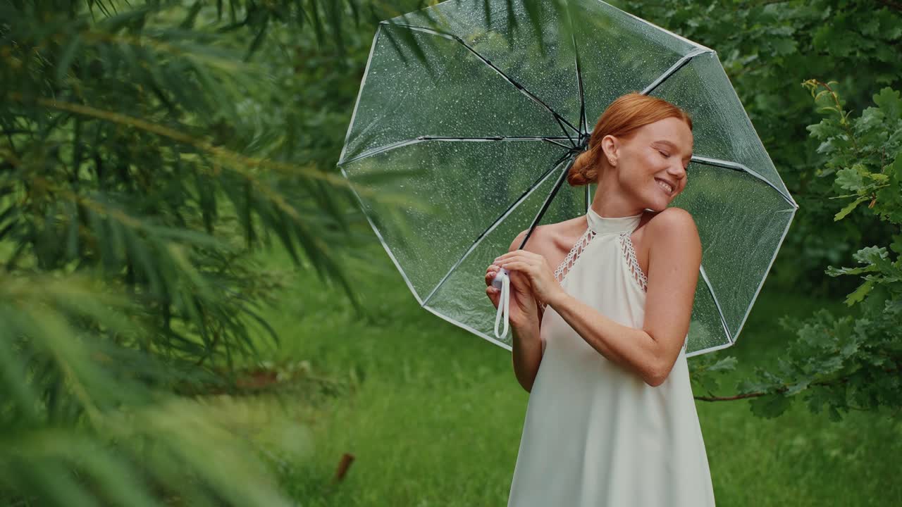 Woman with umbrella in a forest on a rainy day