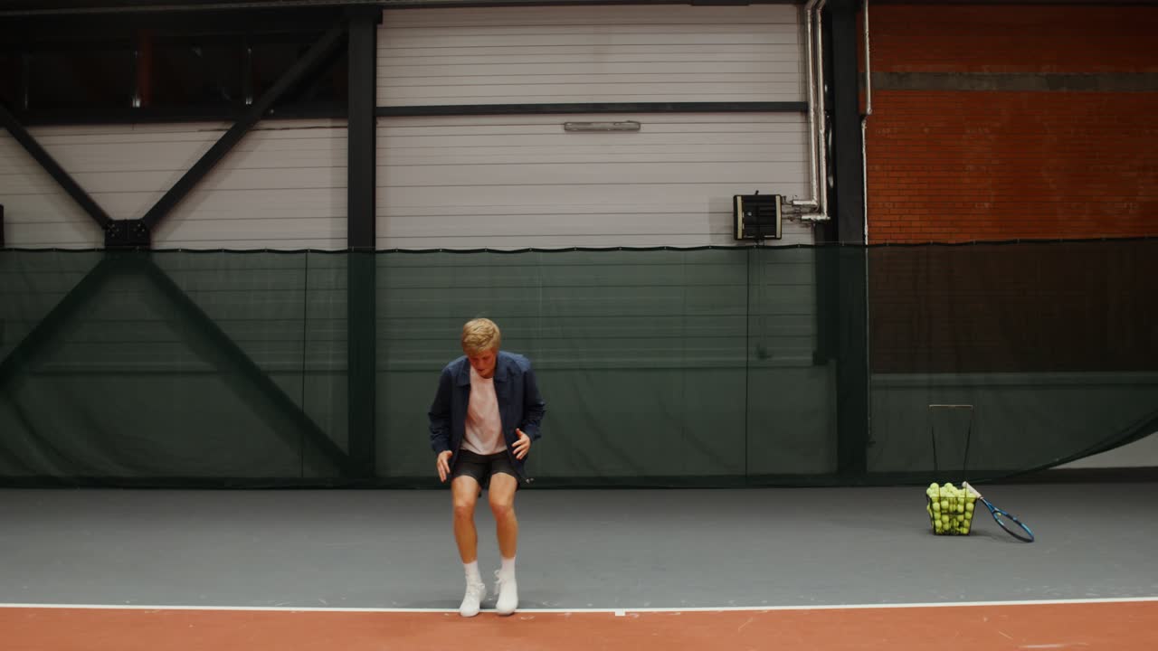 человек празднует очко на крытом теннисном корте