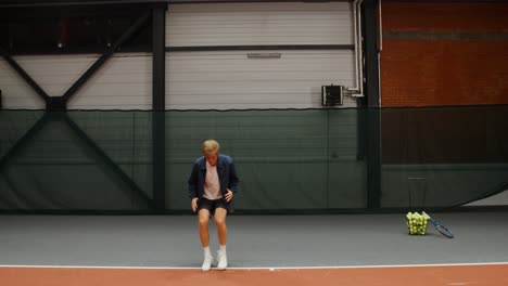 man celebrating a point on an indoor tennis court