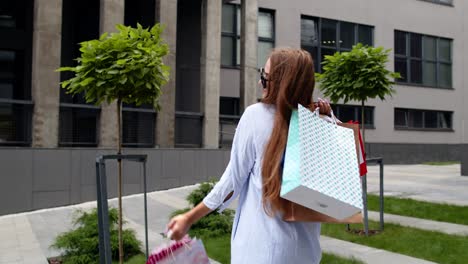 Chica-Sosteniendo-Coloridas-Bolsas-De-Compras,-Alegrándose-De-Los-Descuentos-En-La-Tienda-De-Moda,-Disfrutando-De-Las-Compras