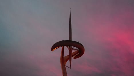 montjuïc telecommunications tower: silhouetted against the golden barcelona sunset. centered gimbal shot