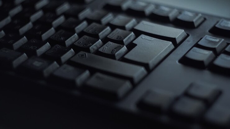 Primo piano di una mano che digita su una tastiera di computer nera