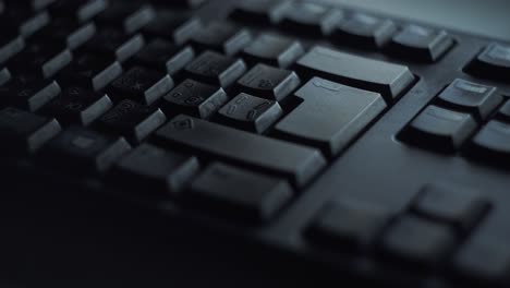 close-up of hand typing on a black computer keyboard