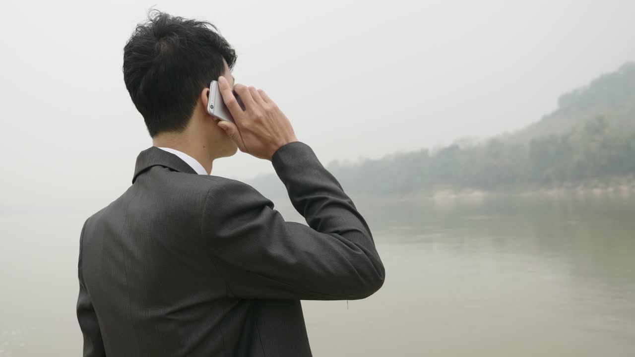 Businessman on a phone call by the river