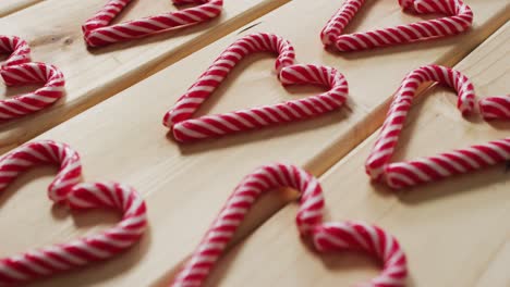 video of red and white candy canes on wooden background