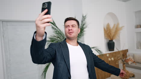 athletic caucasian man having video conversation. man points at something behind him and turns to the sides.